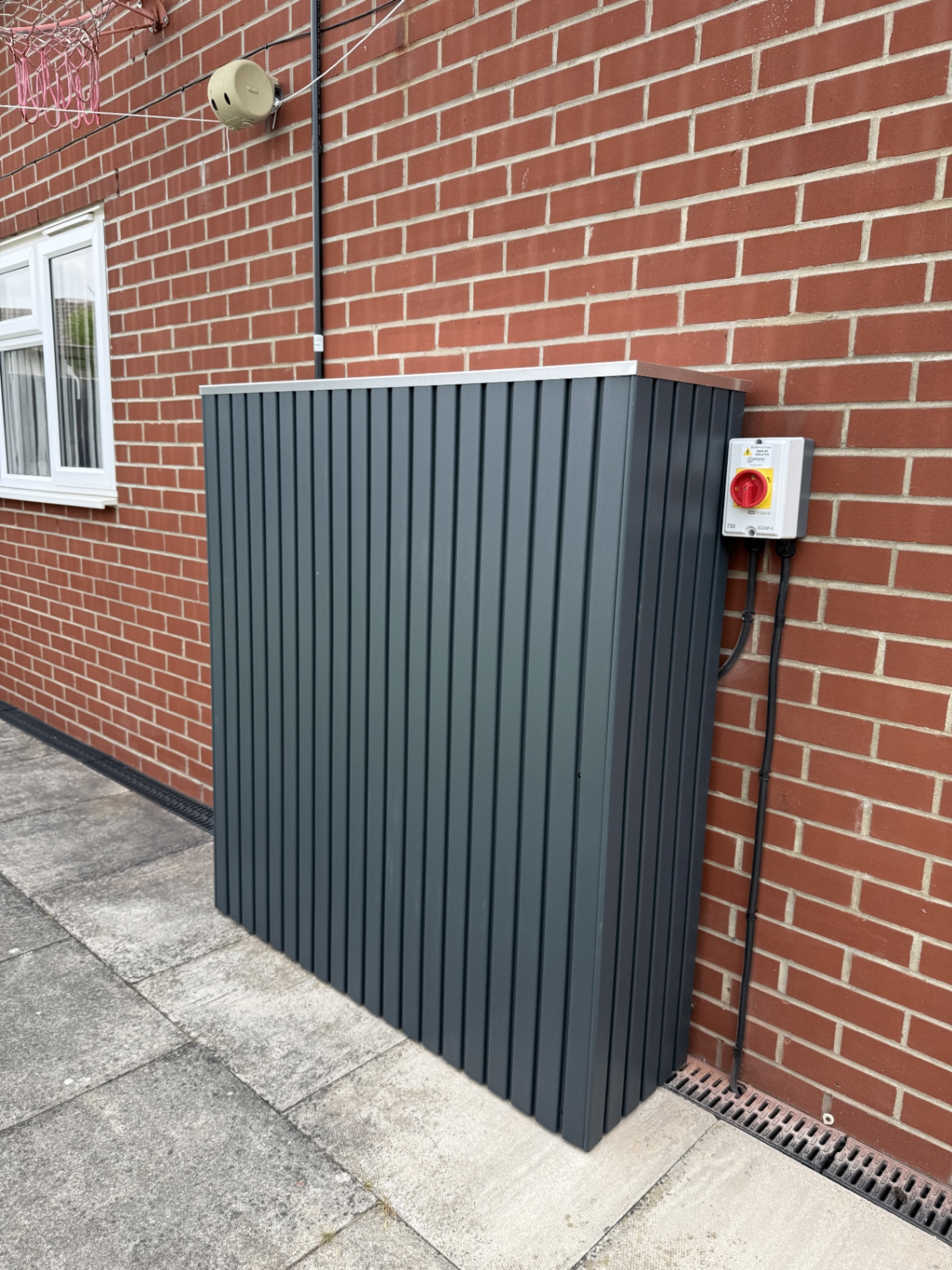 Outdoor battery storage cabinet installed neatly against a brick wall at a recent Midlands job