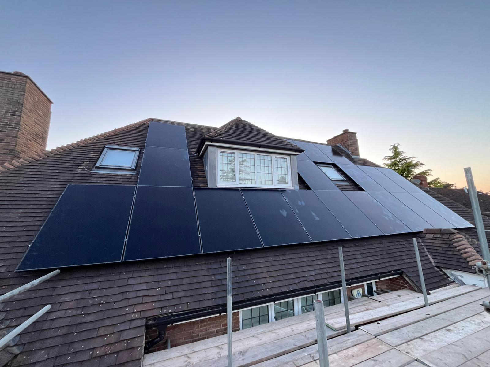 Completed domestic solar panel installation across a large pitched roof at dusk